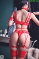 A woman in a red lingerie is posing for the camera.