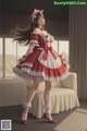 A woman in a red and white dress is posing for a picture.