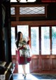 A woman standing in front of a wooden door.