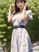 A woman in a floral dress posing for a picture.