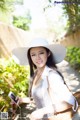 A woman in a white hat holding a cell phone.