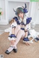 A woman in a blue and white outfit sitting on a rug.